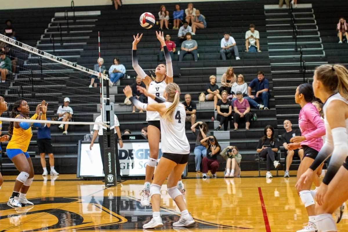 In game 1, junior Ava Carrasquillo sets it to the outside against Elkins.