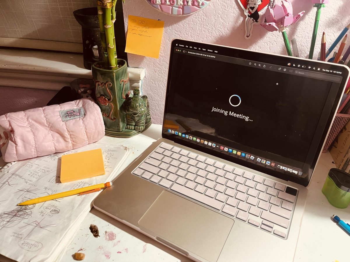 A distance learning set-up in a bedroom similar to those of the COVID lockdown, featuring a ZOOM loading screen