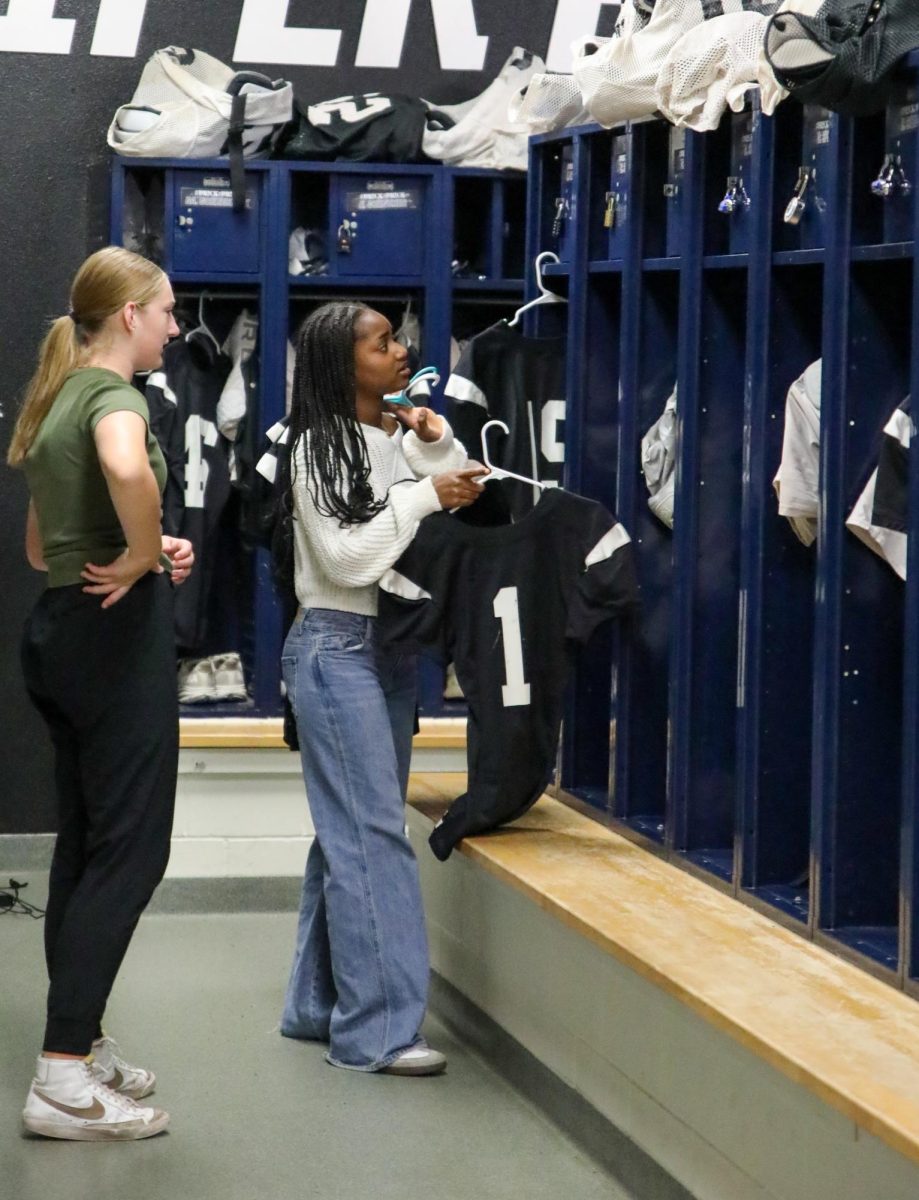 Freshman Natiyana Jackson hangs up jerseys in the varsity football locker room.