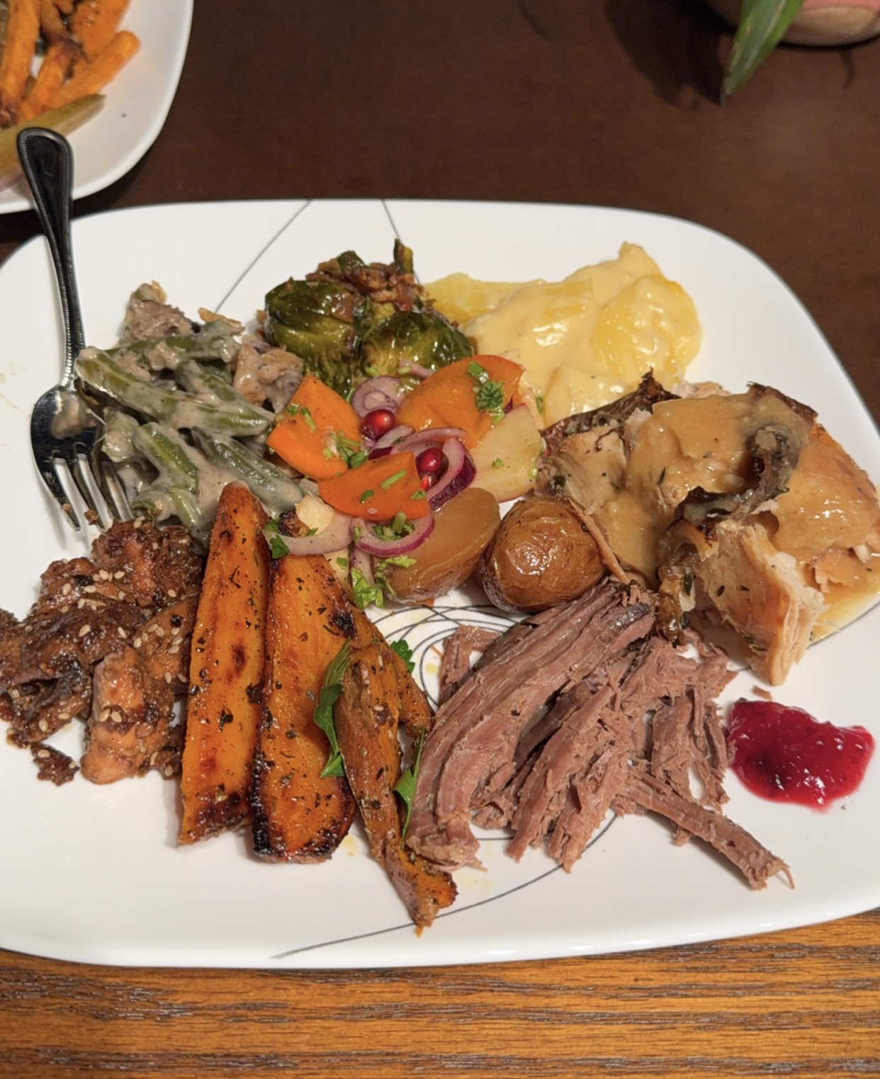 Families enjoy a scrumptious plate of Thanksgiving foods including Potatoes au Gratin, salmon bites, sweet potato wedges, roasted turkey and more.